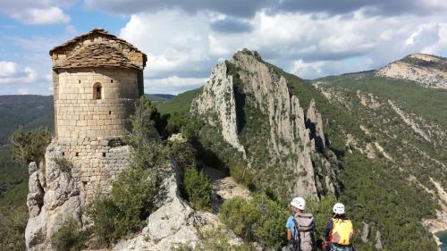 two people standing on top of a mountain with a tower at La Caseta d'Àger in Ager