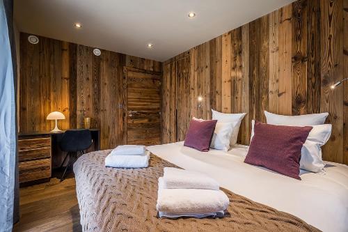 une chambre avec un grand lit avec deux oreillers dessus dans l'établissement Moulin Chalets Les Gets - by EMERALD STAY, aux Gets