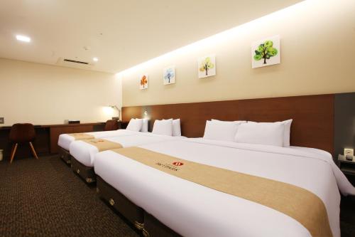 a hotel room with two large beds in it at Hotel Skypark Kingstown Dongdaemun in Seoul
