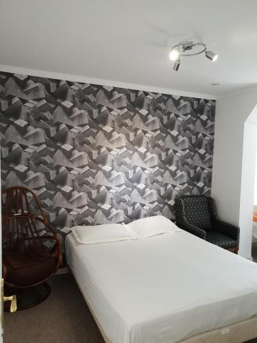 Cet appartement comprend une chambre dotée d'un lit blanc et d'un mur avec une cloison latérale. dans l'établissement Appartement Centre Bordeaux avec Garage sur demande, à Bordeaux