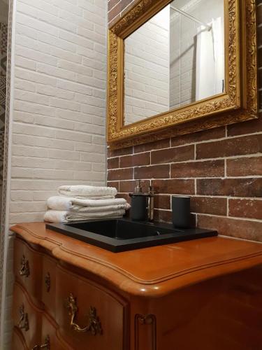 La salle de bains est pourvue d'un lavabo avec miroir et de serviettes. dans l'établissement Appartement Centre Bordeaux avec Garage sur demande, à Bordeaux