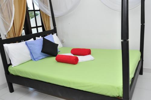 a bedroom with a bed with two pillows on it at Bon Accord Mirissa in Mirissa