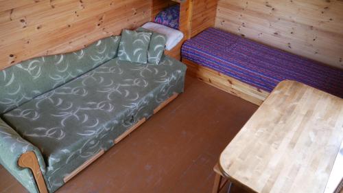 a living room with a couch and a table at Metsjärve kämpingumajake in Puskaru