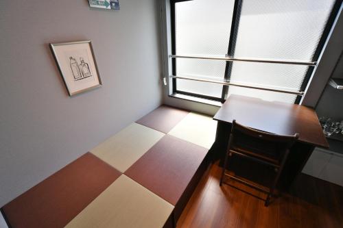 a small room with a table and a window at Stylewood Sangenjaya in Tokyo