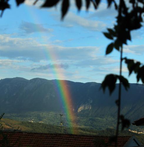 a rainbow in the sky with mountains in the background at mansarda fiorita in Abatemarco