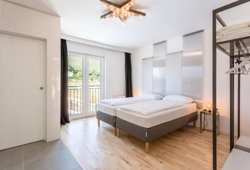 a white bedroom with a bed and a window at Villa Mila Kastela in Kastel Novi