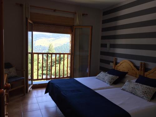 Hotel Supermolina في لا مولينا: غرفة نوم بسريرين ونافذة كبيرة