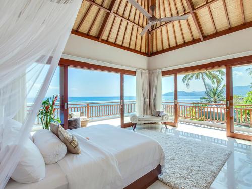 a bedroom with a bed and views of the ocean at Villa Tirta Nila by Elite Havens in Candidasa