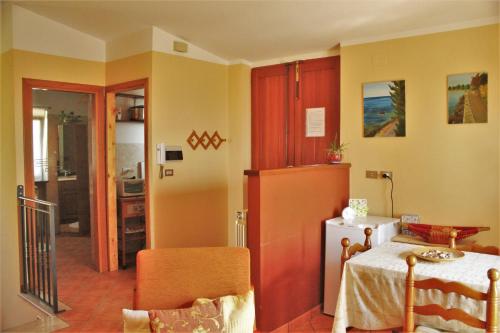 a kitchen with a table and a refrigerator at mansarda fiorita in Abatemarco