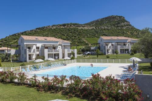 une villa avec une piscine en face d'une montagne dans l'établissement Résidence Odalys Casa d'Orinaju, à Oletta