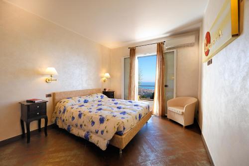 een slaapkamer met een bed en uitzicht op de oceaan bij Poggio dei Gorleri in Diano Marina