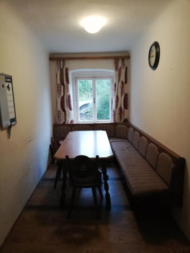 a room with a table and a couch and a window at Amtmannhaus Ferienunterkunft in Irdning