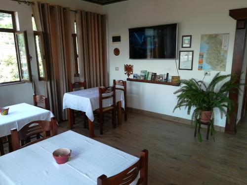 a restaurant with two tables and chairs and a tv at B&BSheshalliu in Berat