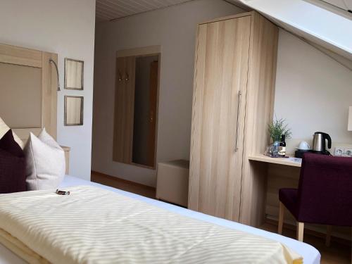 a bedroom with a bed and a wooden cabinet at Haus Mechthild Sindelfingen-Maichingen Self Check-In in Sindelfingen