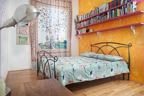 ein Schlafzimmer mit einem Bett und einem Regal mit Büchern in der Unterkunft FL Apartments Casa d'artista in Rom