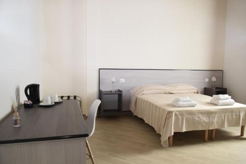 een slaapkamer met een bed, een tafel en een bureau bij La Formica in Civitavecchia