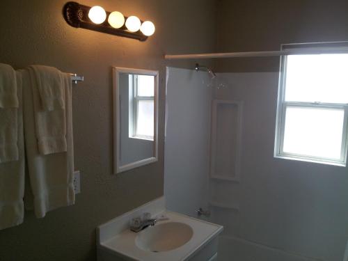 a bathroom with a sink and a toilet and a window at Oasis Boutique Motel in Boulder City