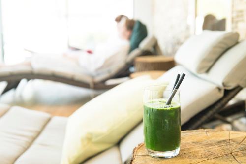 a green drink sitting on a table in a living room at Hotel Storck in Bad Laer