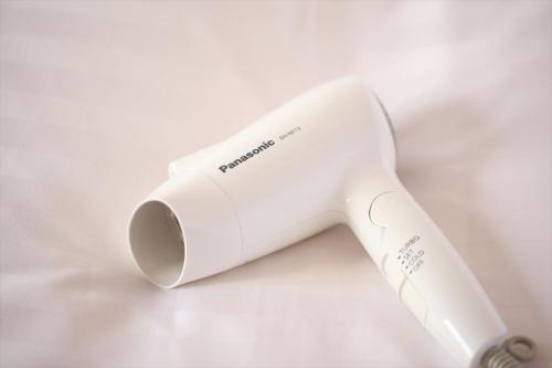 a white hair dryer sitting on a white surface at Hotel Hokke Club Hiroshima in Hiroshima