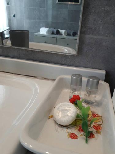 a bathroom sink with two glasses and a flower on it at Prenociste Nikolas Grand in Smederevo