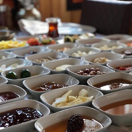 einem Tisch voller Schüsseln verschiedener Arten von Lebensmitteln in der Unterkunft Abant Yeşil Vadi Koç Pansiyon in Dereceören