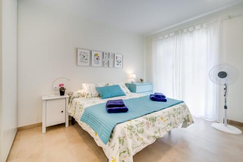 a bedroom with a bed with blue towels on it at Vivalidays Josep in Blanes