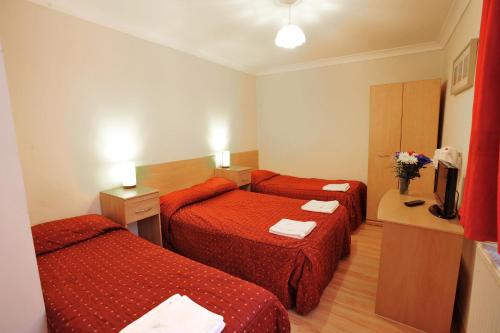 a hotel room with two beds and a television at Elmwood Hotel in London