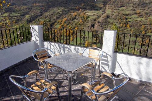 a table and chairs on a balcony with a view at Apartamentos Vista Veleta in Capileira