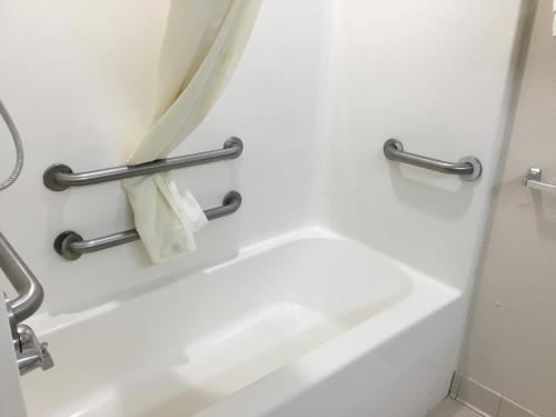 a bathroom with a white tub and a towel rack at Microtel Inn & Suites by Wyndham Augusta/Riverwatch in Augusta