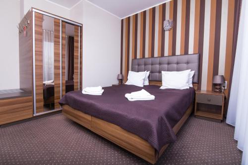 a bedroom with a large bed with towels on it at Hotel Jastarnia in Jastarnia