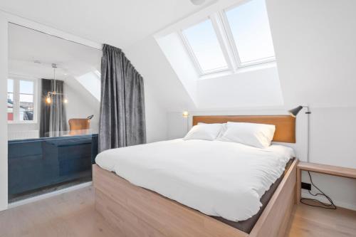 1 dormitorio con 1 cama grande y baño en Sea Story by Frogner House en Stavanger