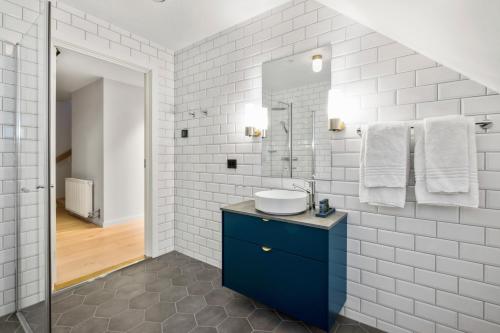 uma casa de banho branca com um lavatório e um espelho em Sea Story by Frogner House em Stavanger
