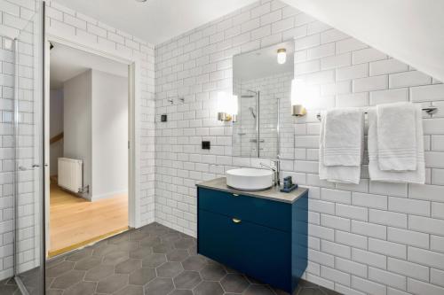 a white bathroom with a sink and a mirror at VANDER - Sea Story in Stavanger
