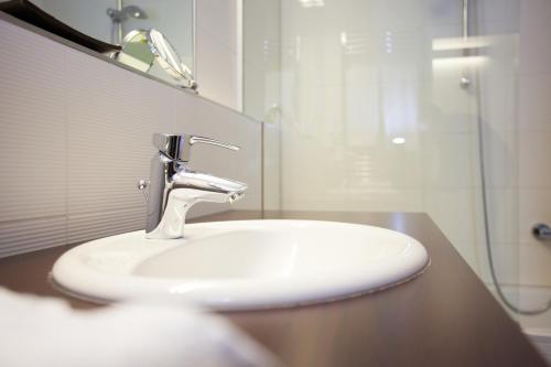 a bathroom with a sink and a shower at Hotel Schwarzer Bär in Linz