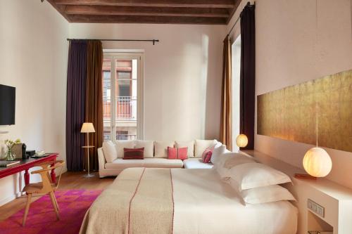 バルセロナにあるHotel Neri – Relais & Chateauxのベッドとソファのあるホテルの部屋