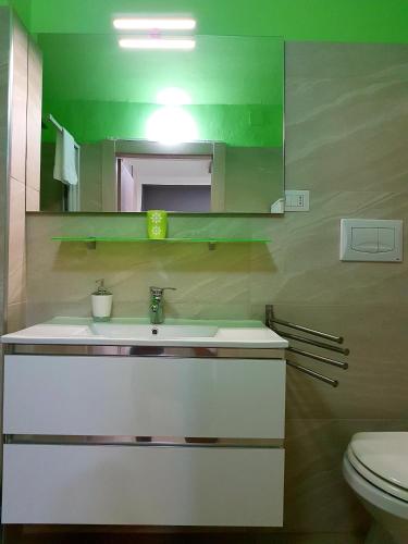a bathroom with a sink and a mirror and a toilet at Room n.22 in Taranto