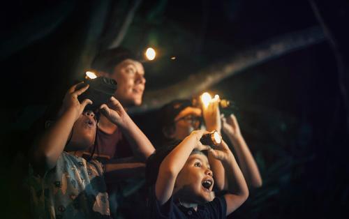 a group of people holding candles and holding lights at Shangri-La Rasa Ria, Kota Kinabalu in Kota Kinabalu