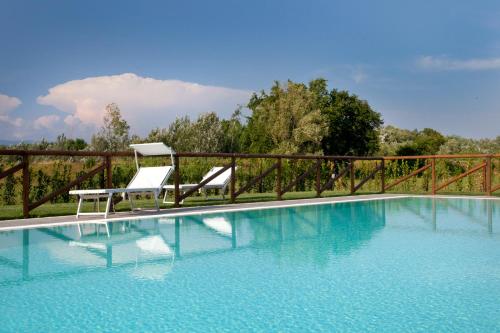 a swimming pool with two chairs and a table at Tenuta San Giovanni Lucca in Lucca