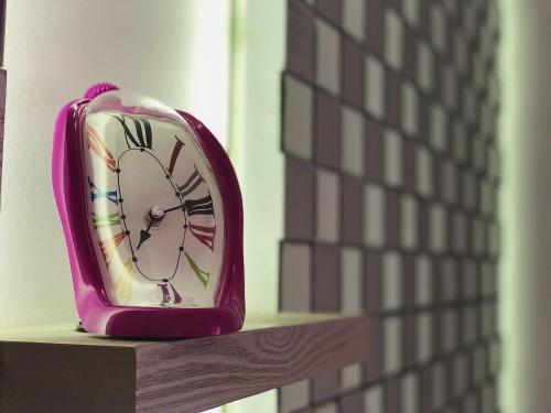 a pink clock sitting on top of a shelf at Retiro del Teatro Almagro in Almagro