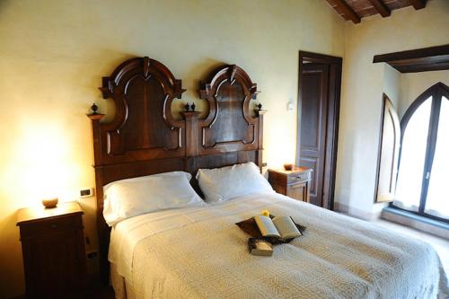 a bedroom with a large bed with a wooden headboard at Agriturismo Monastero Di San Biagio in Nocera Umbra