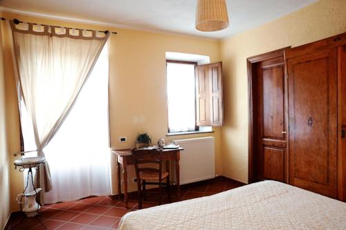 a bedroom with a bed and a table and a window at Agriturismo Monastero Di San Biagio in Nocera Umbra