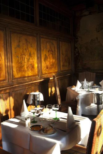 a dining room with two tables with white table cloth at Maison Kammerzell - Hotel & Restaurant in Strasbourg
