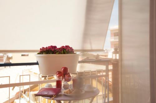 a table with a potted plant on a balcony at Viria B&B Sorrento in Sorrento