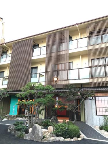 a building with a tree in front of it at Arima Onsen Koki in Kobe