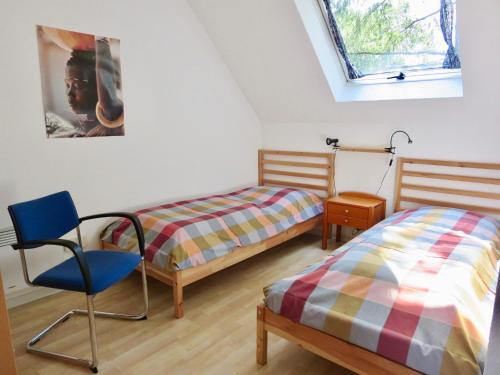 a bedroom with two beds and a chair and a window at Natururlaub Frankenau in Frankenau