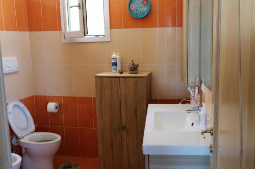 a bathroom with a toilet and a sink at Casa Elicriso in Castelsardo