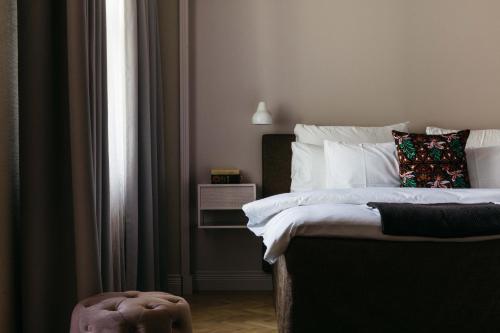 a bedroom with a bed with white sheets and a pillow at Hotel St. George Helsinki in Helsinki