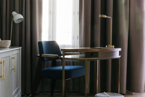 a desk and a chair next to a window at Hotel St. George Helsinki in Helsinki