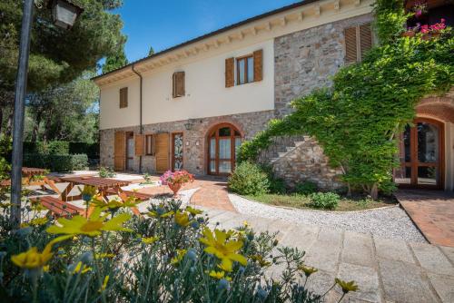 a stone building with a picnic table and flowers at Dolce Vita in Campiglia Marittima