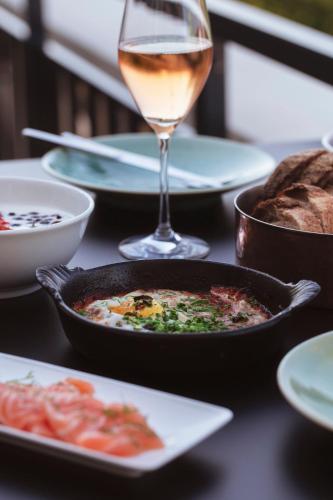 a table with a plate of food and a glass of wine at Hotel St. George Helsinki in Helsinki
